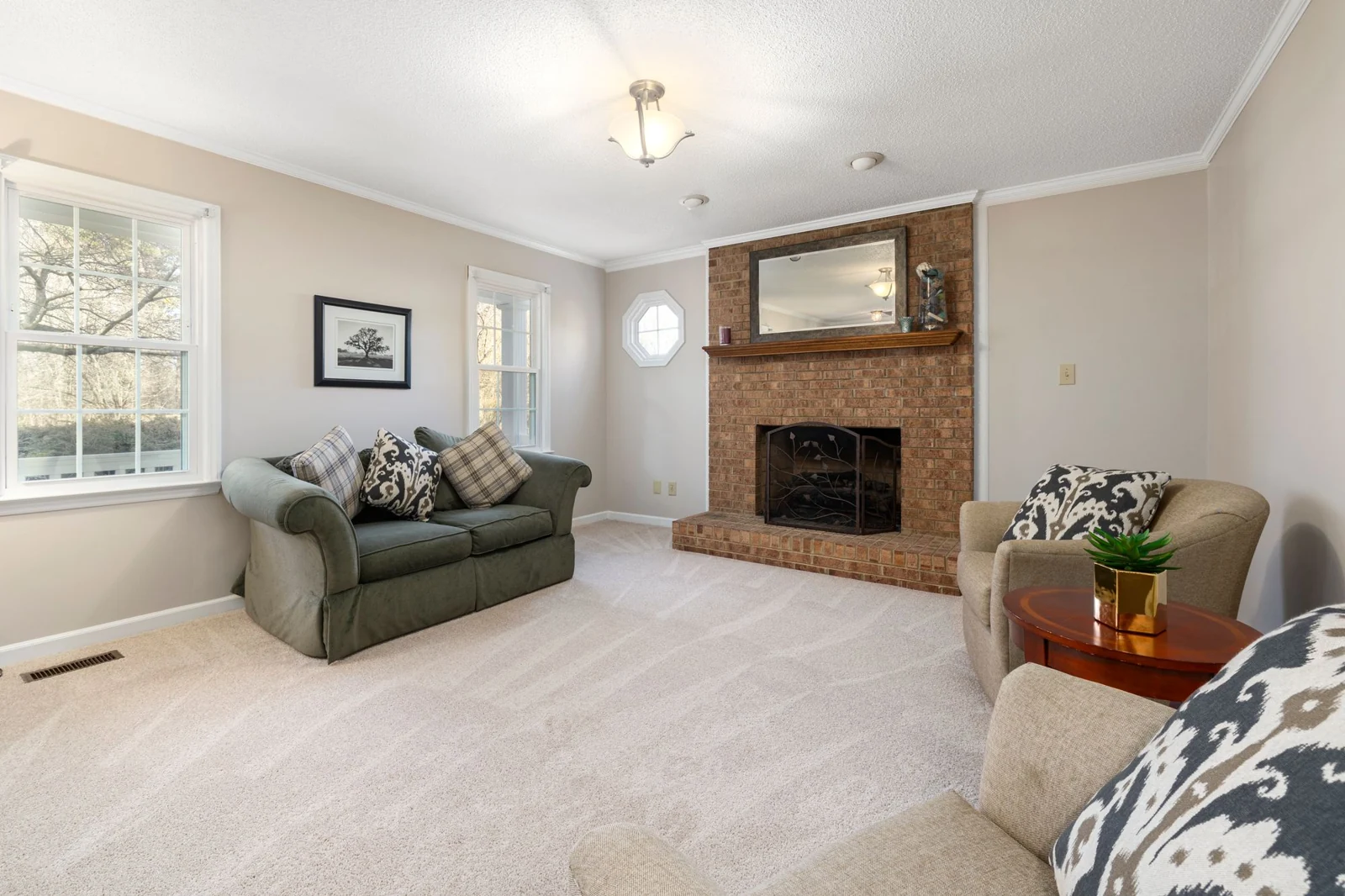 Brick fireplace and raised hearth beside green seating